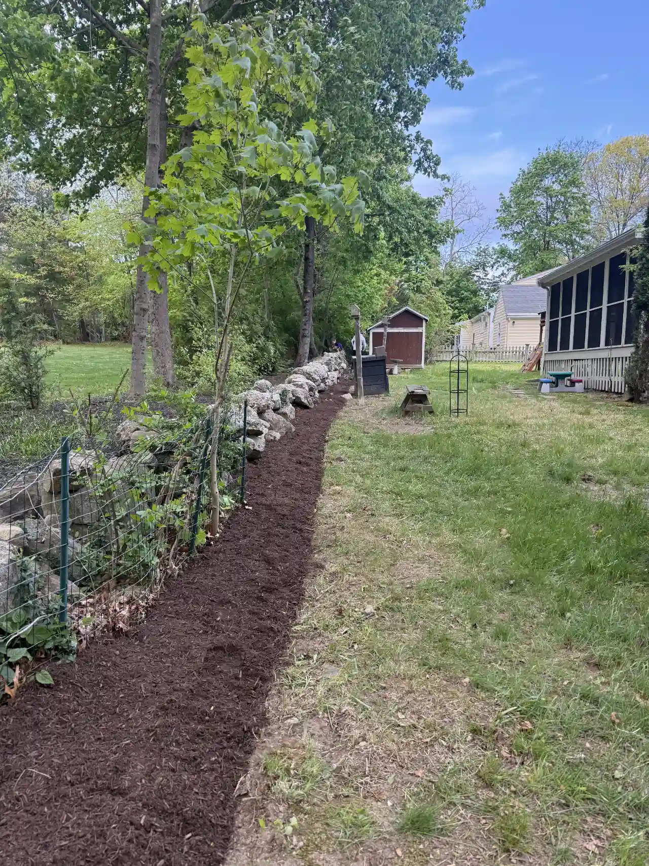 Gloved hands holding quality landscaping mulch
