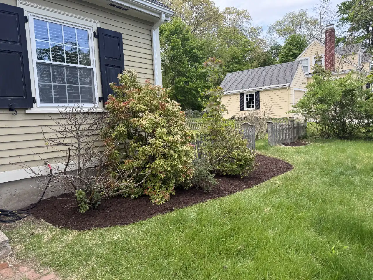 Landscaper spreading mulch in a garden bed